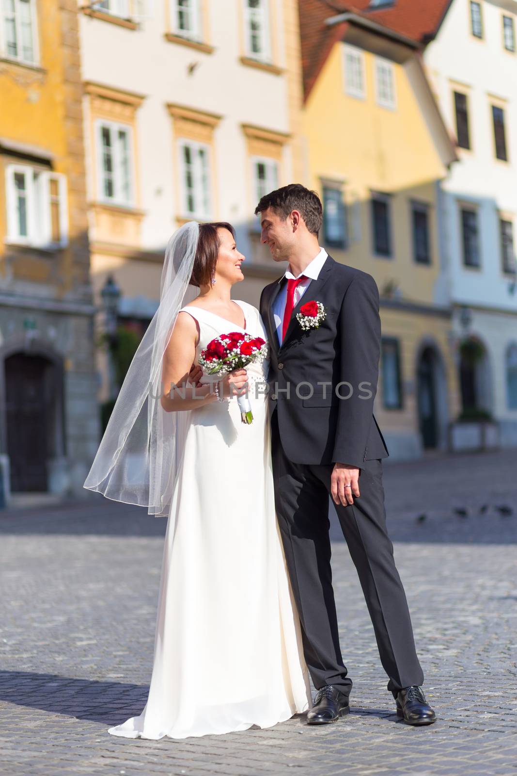 Bride and groom. Portrait of a loving wedding couple on cobbled street in medieval city center of Ljubljana, Slovenia.