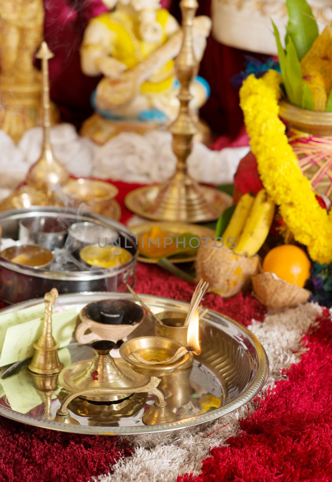 Traditional Indian Hindu religious praying items in ear piercing ceremony for children. Focus on the oil lamp. India special rituals events.