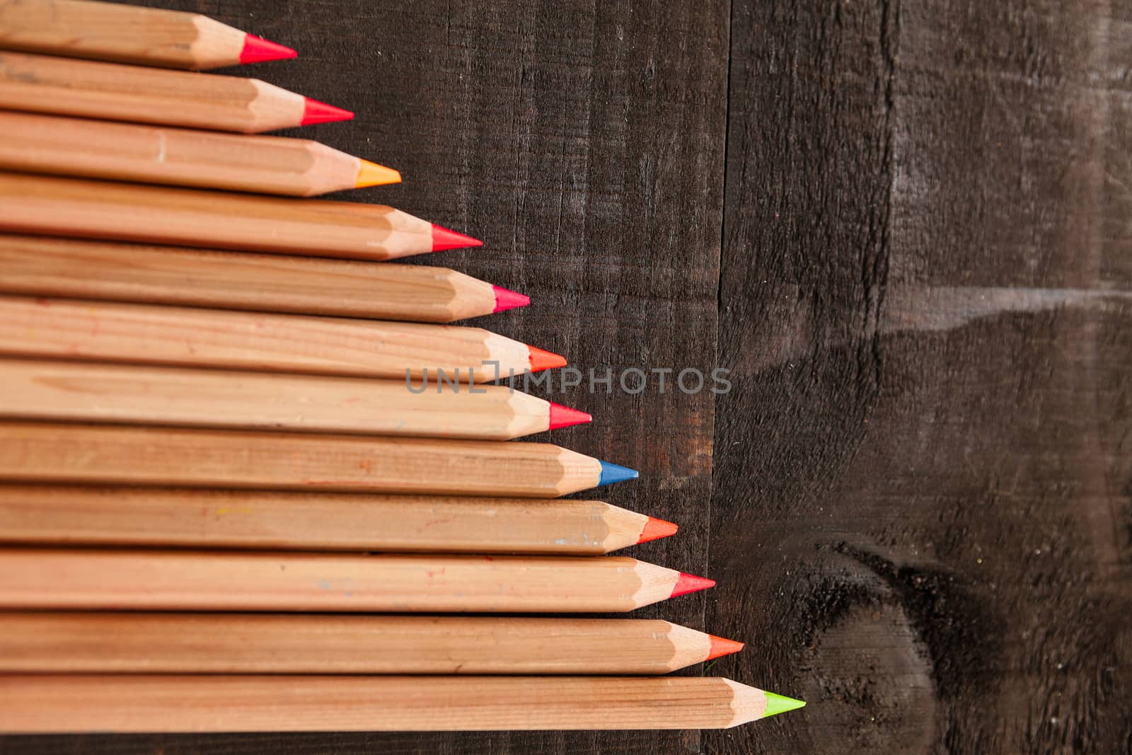 Group of crayons and they are on wooden background, the picture is blurred
