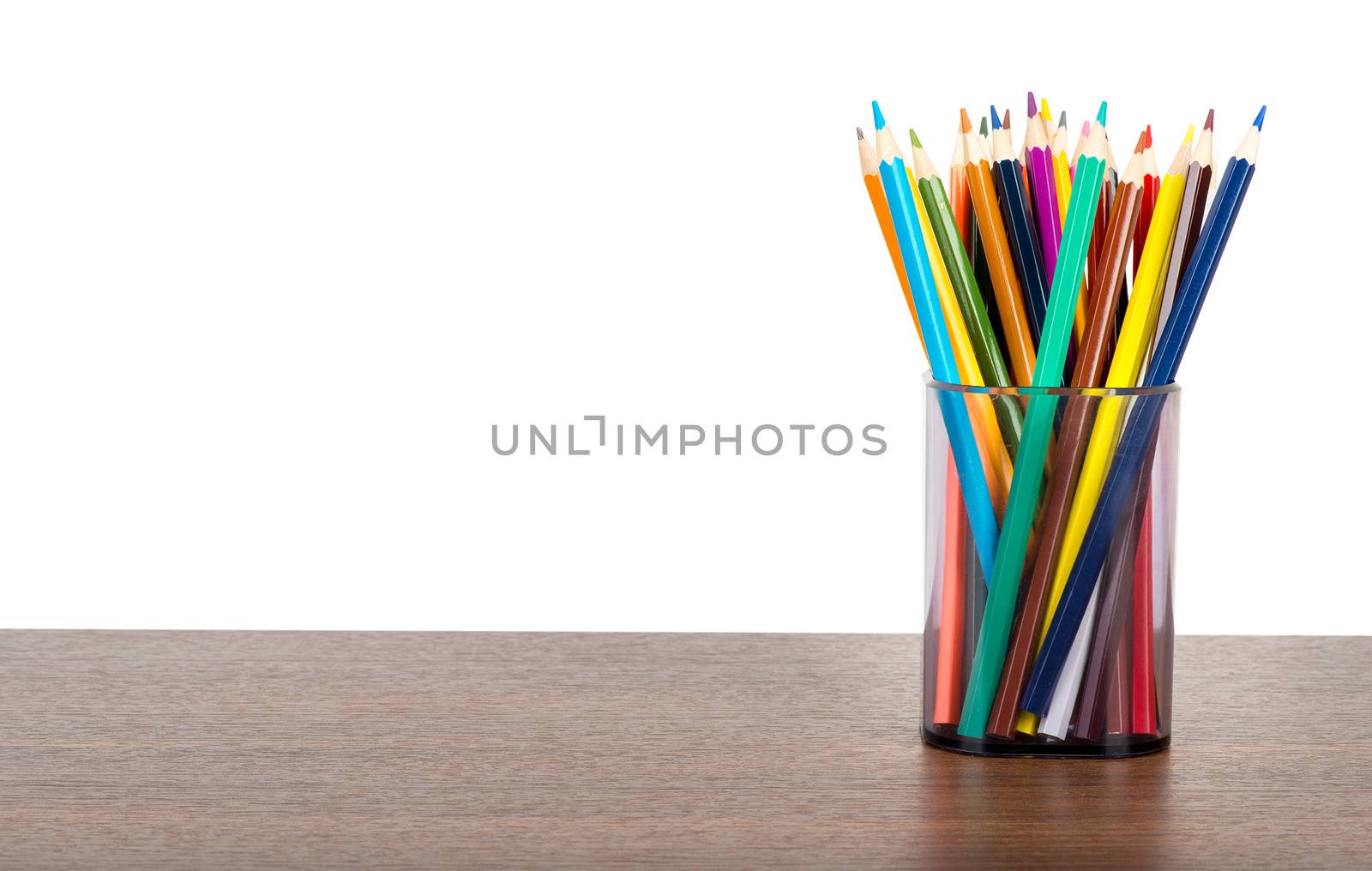 Crayons in pencil cup on table isolated on white background
