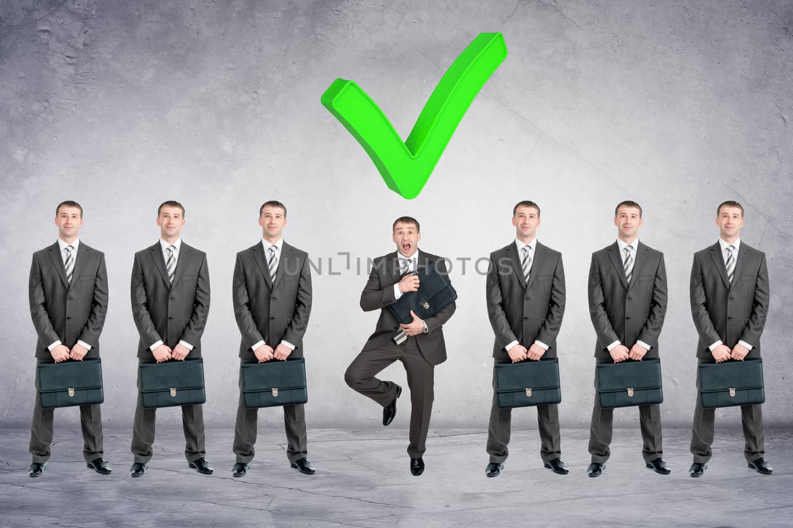 Set of businessmen with big tick on grey wall background