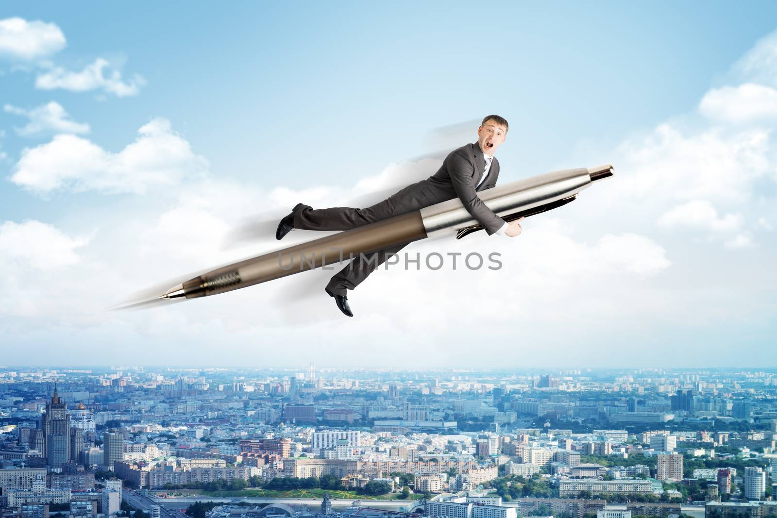 Businessman flying on big pen above city scape
