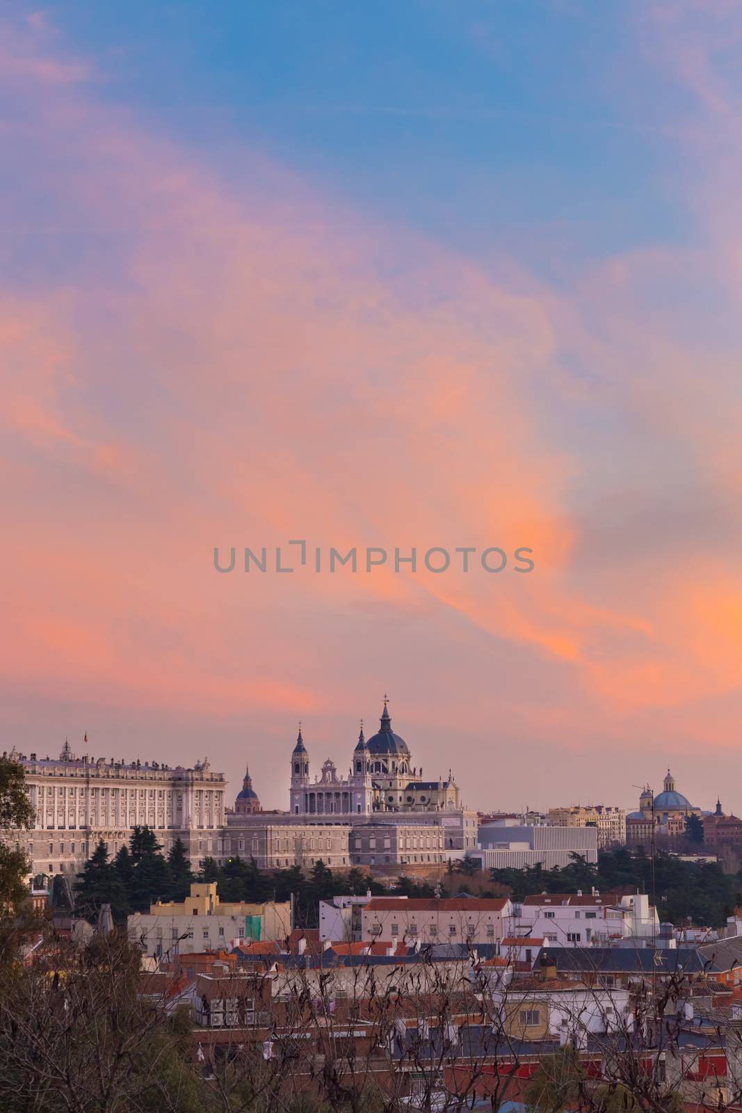 Madrid, Spain skyline at Santa Maria la Real de La Almudena Cathedral and the Royal Palace in vivid colorful sunset.