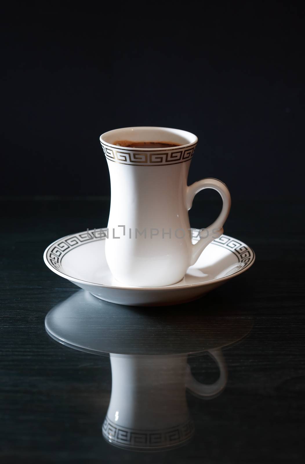 Elegant white cup of black coffee on dark background