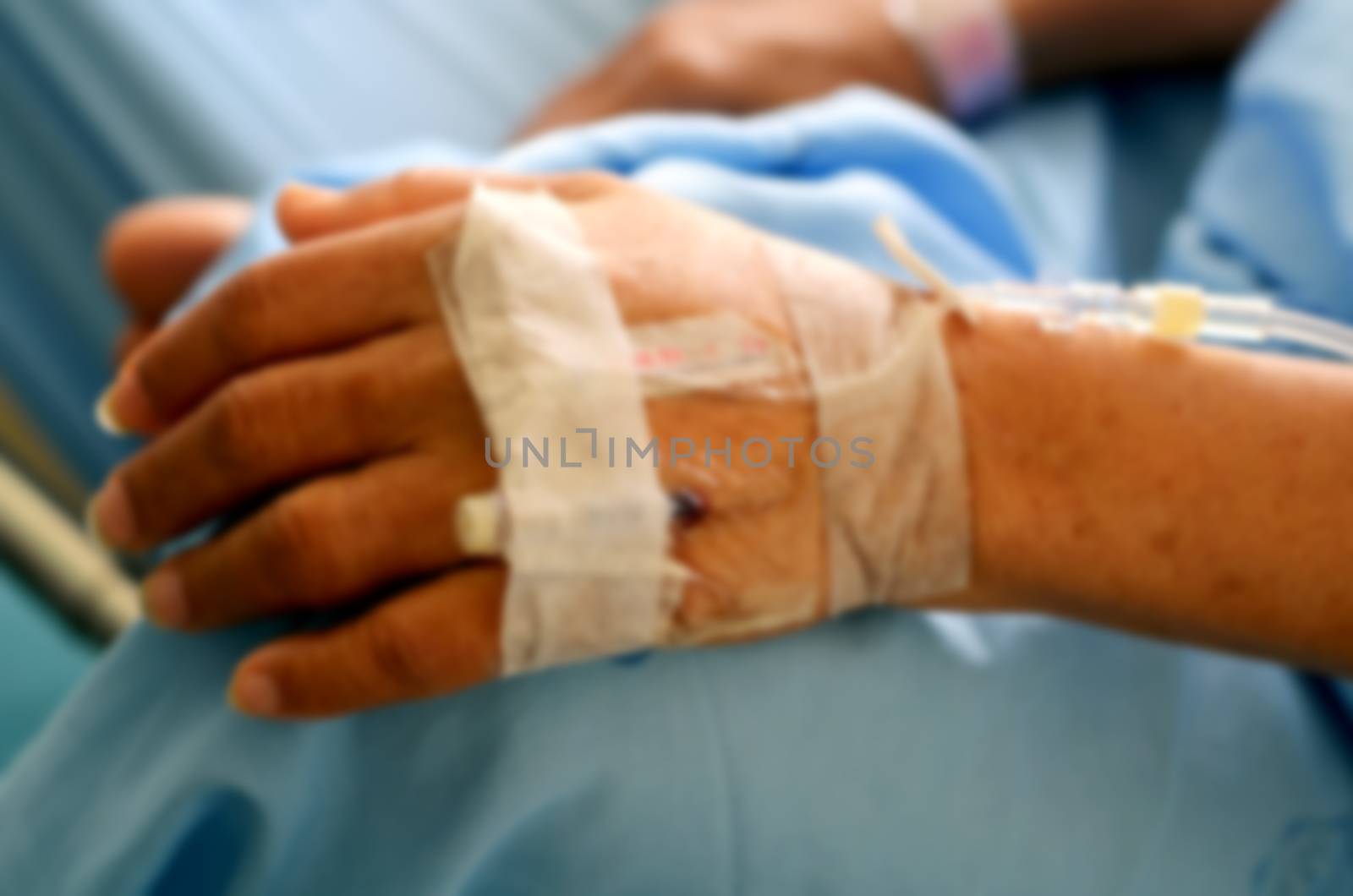 Abstract blurred IV Solution in a senior patient hand