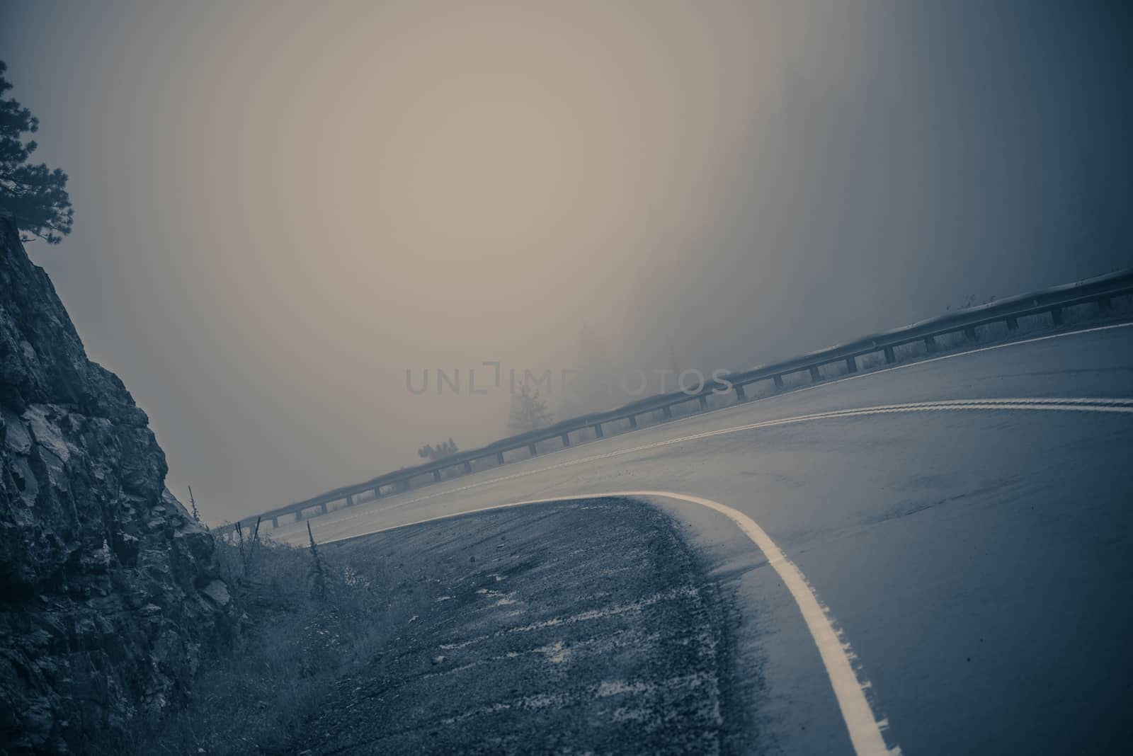 Foggy Curved Road. Dangerous Mountain Road. Bluish Color Grading.