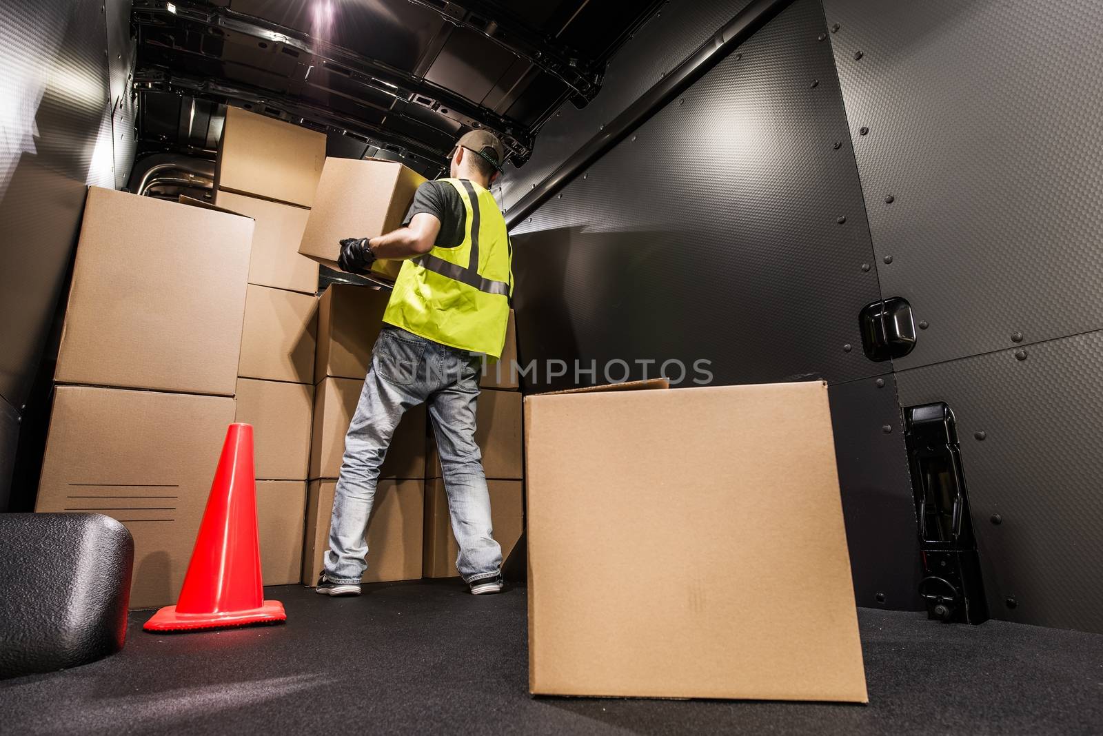 Cargo Van Loading by Worker. Man Carrying Boxes In the Cargo Van For Customer Delivery. Shipment Preparation and Processing.