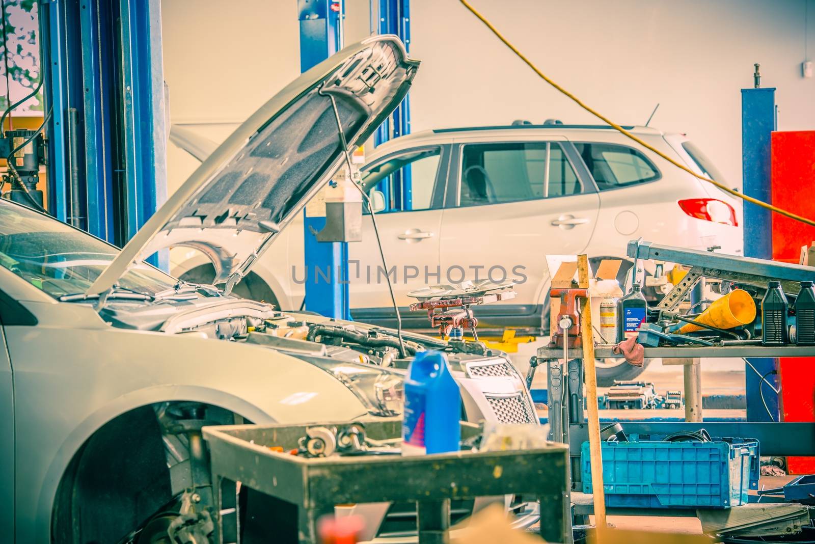 Cars Repairing in Auto Service. Broken Cars on Lifts.