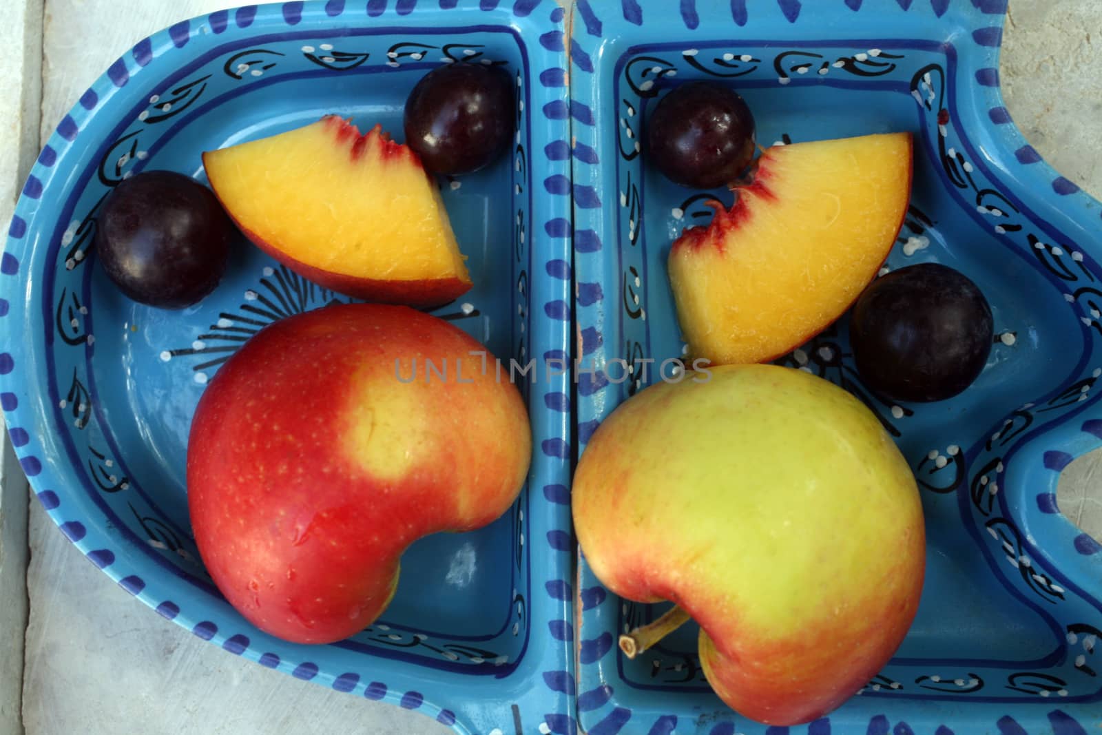 Grapes, peaches and apples in a blue bowl