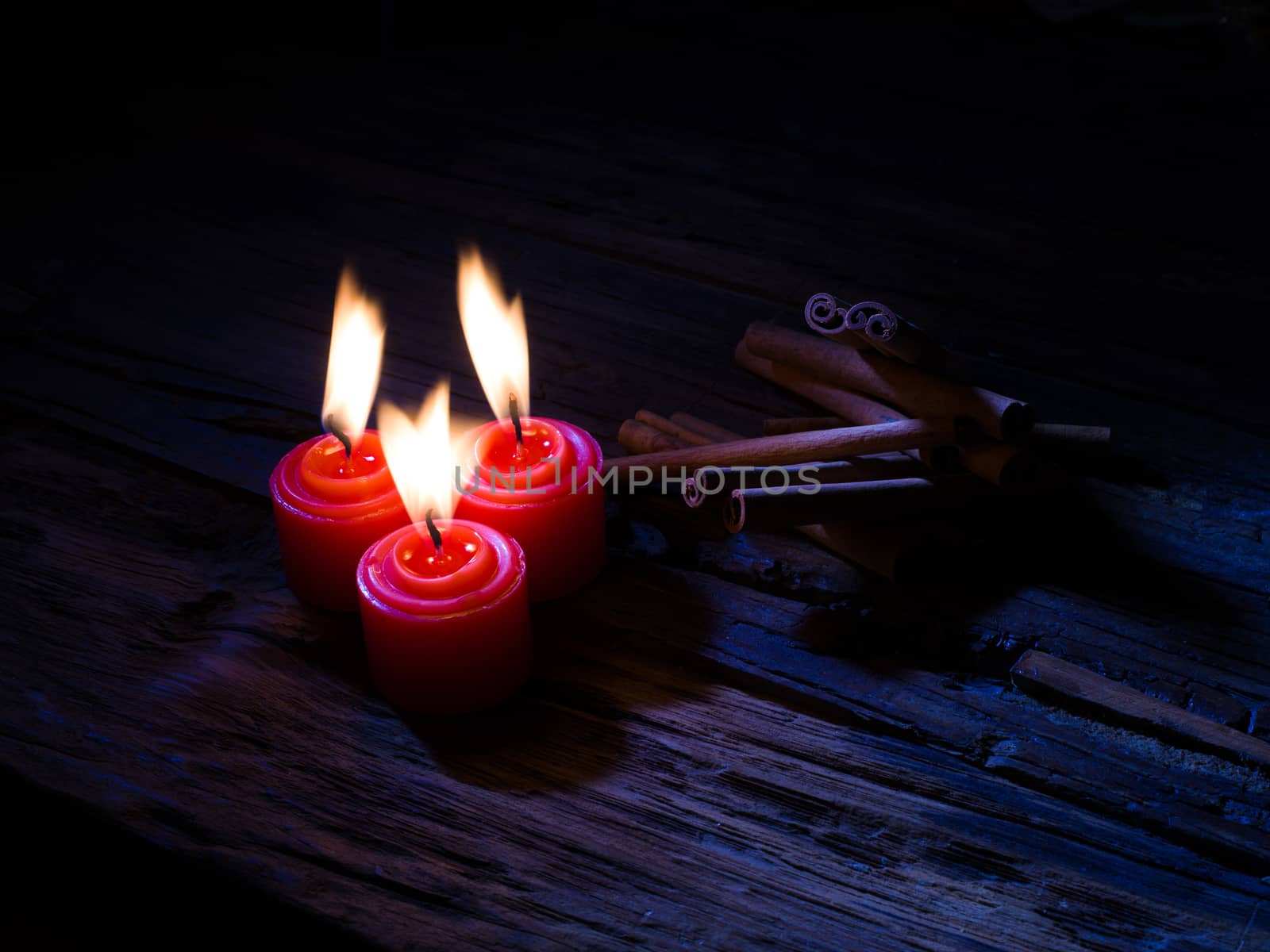 cinnamon sticks on brown wooden tables and red candles