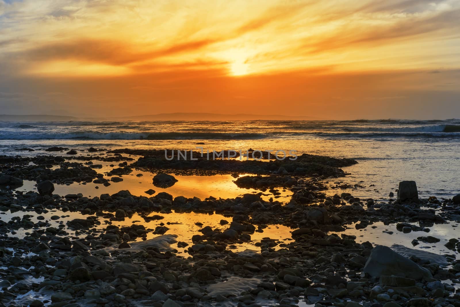 reflections at rocky beal beach near ballybunion on the wild atlantic way ireland with a beautiful yellow sunset