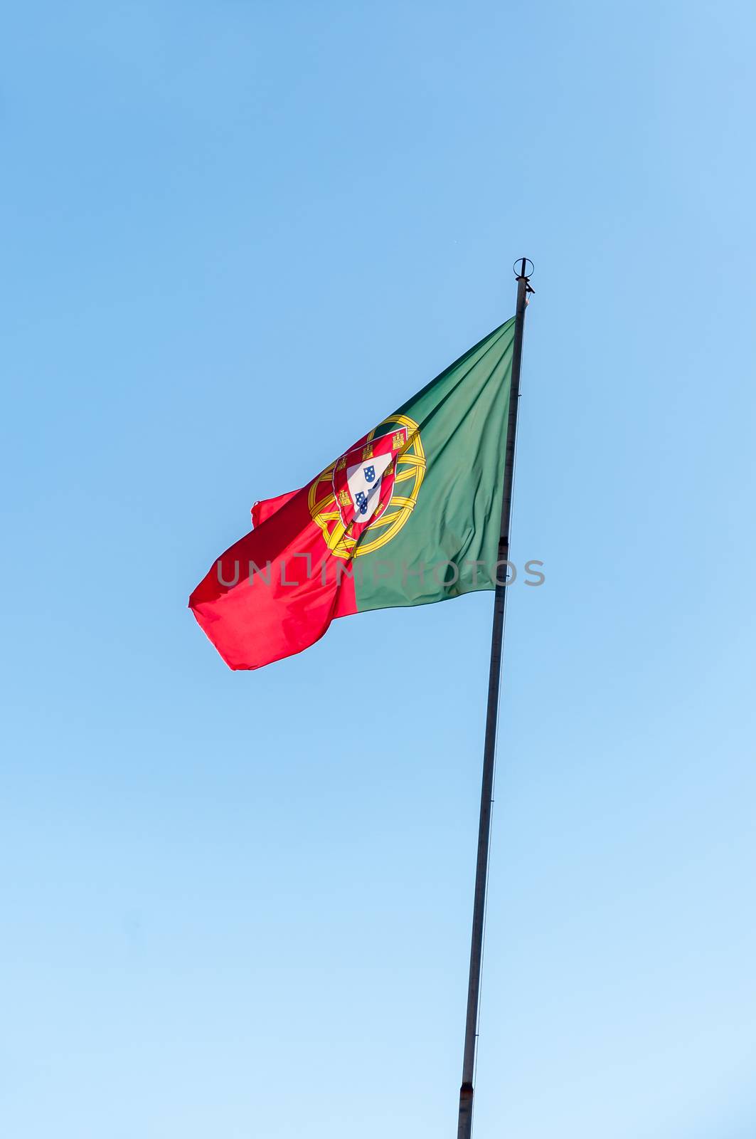 Portuguese flag on a pole against beautiful sky