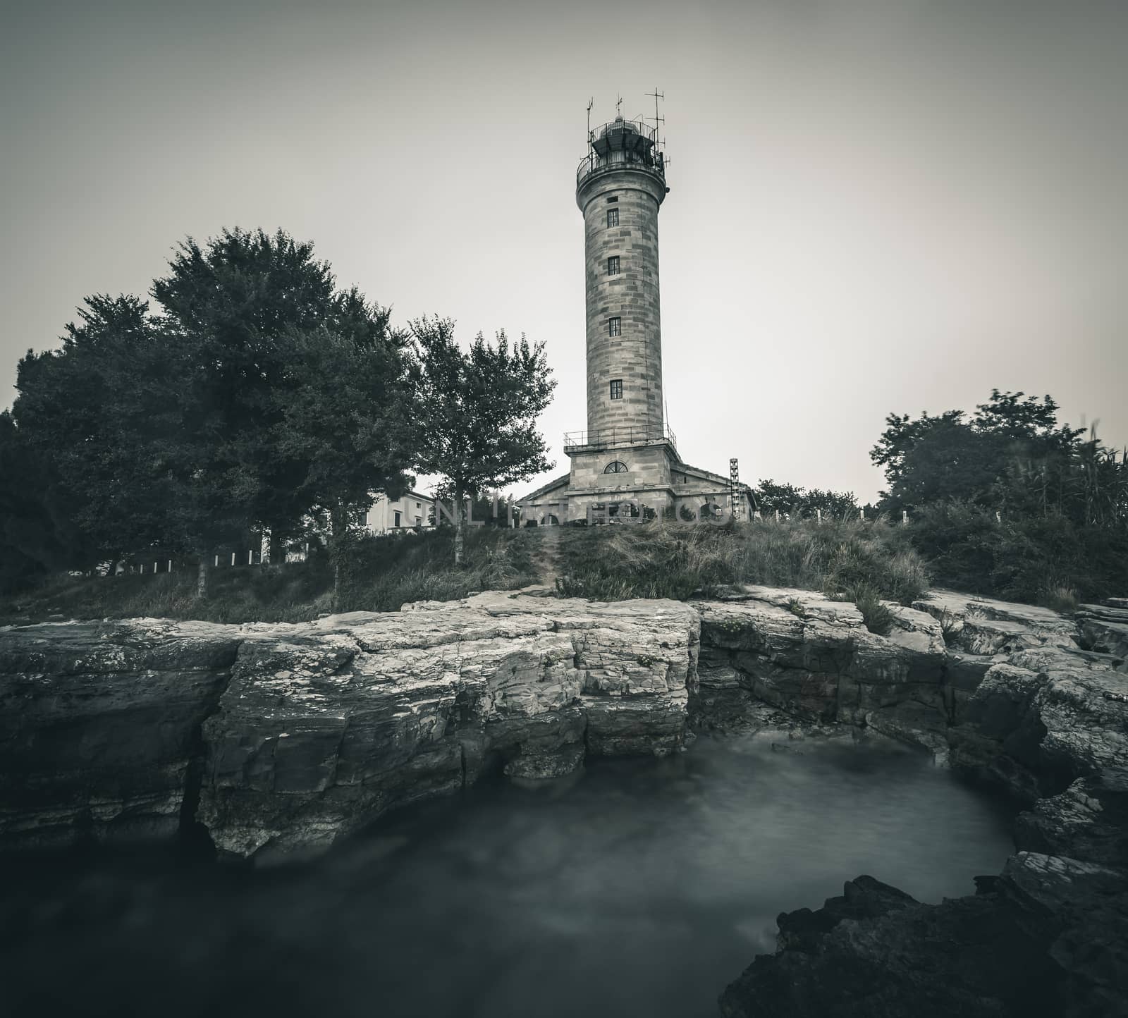 Savudrija Lighthouse on Rocky Coast, the Most Western Point of the Balkans Peninsula and the Oldest Lighthouse in Croatia (Built 1818). Black and White.