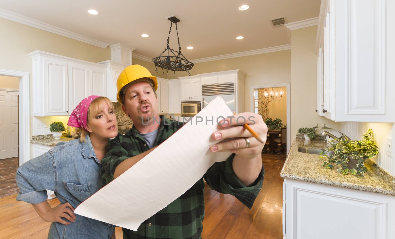 Male Contractor in Hard Hat Discussing Plans with Woman in Custom Kitchen Interior.