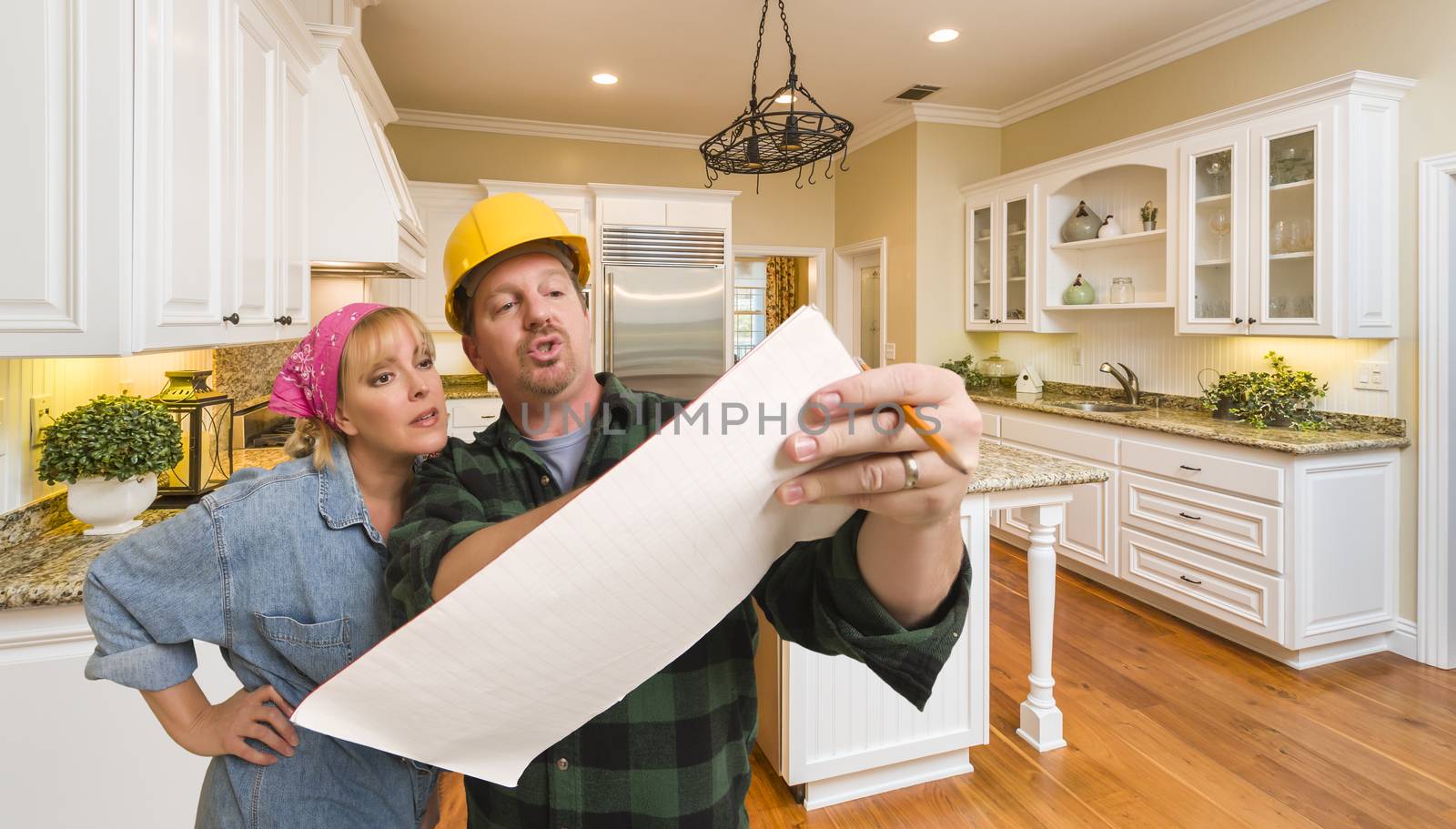 Male Contractor in Hard Hat Discussing Plans with Woman in Custom Kitchen Interior.