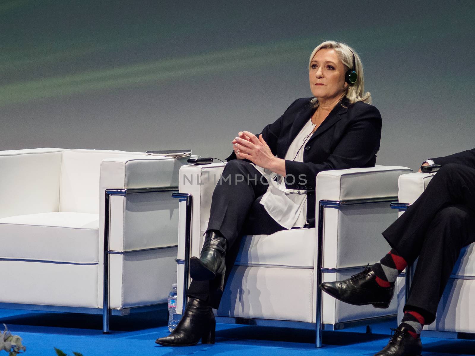 ITALY, Milan: French President of the National Front Marine Le Pen listens during a political rally also attended by Italian Secretary of the Northern League Matteo Salvini and other officials at MiCo in Milan, Italy on January 28, 2016. At the same time, demonstrators from the Anti-Fascist Network of Milan march through the city and launch fireworks to protest their meeting.