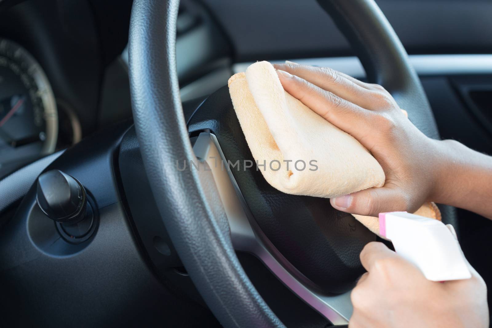 close up hand cleansing car dashboard