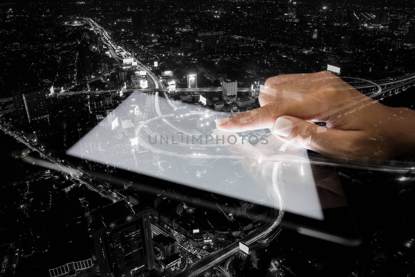 double exposure hand using tablet and city on night background