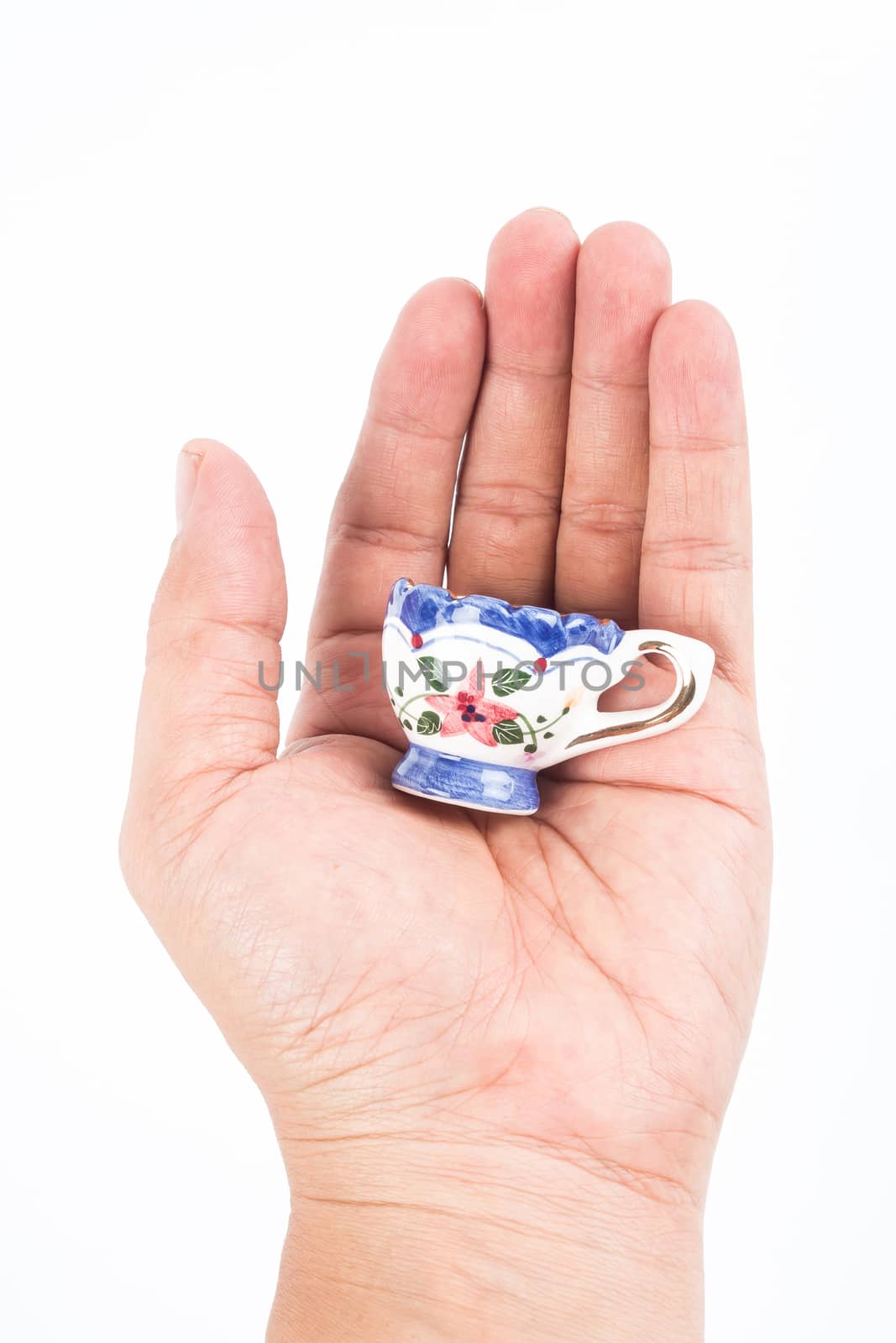 small ceramic cup in hand on white background