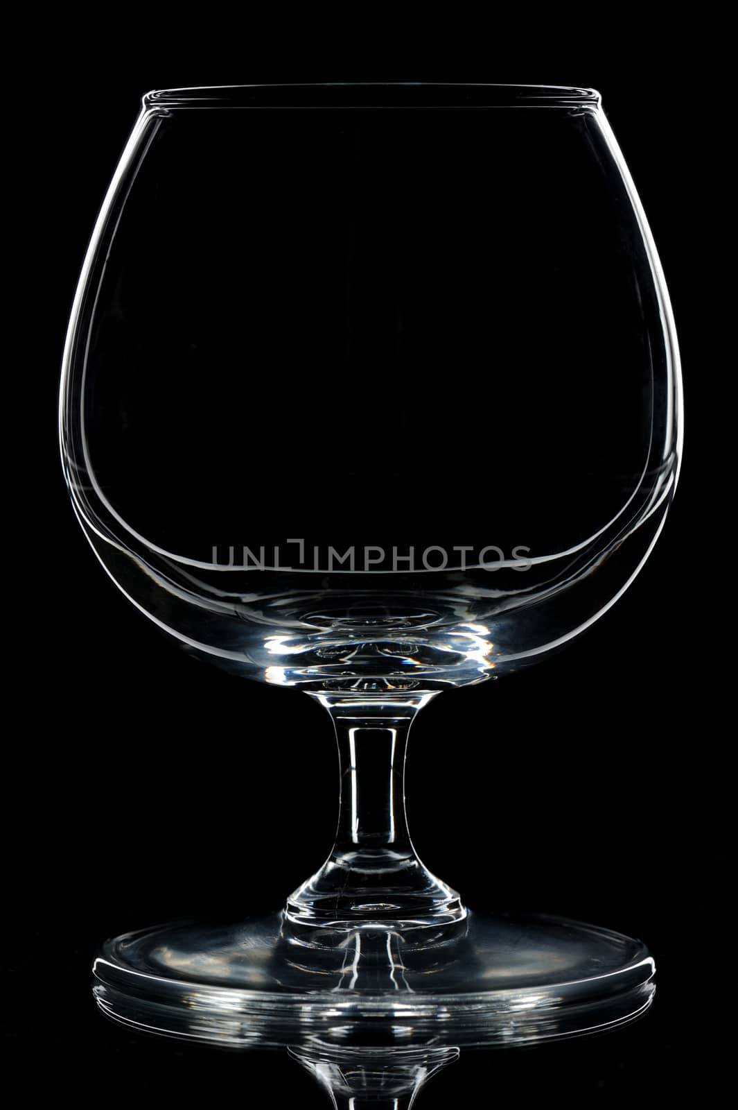 silhouette of Empty cognac glass on black backdrop