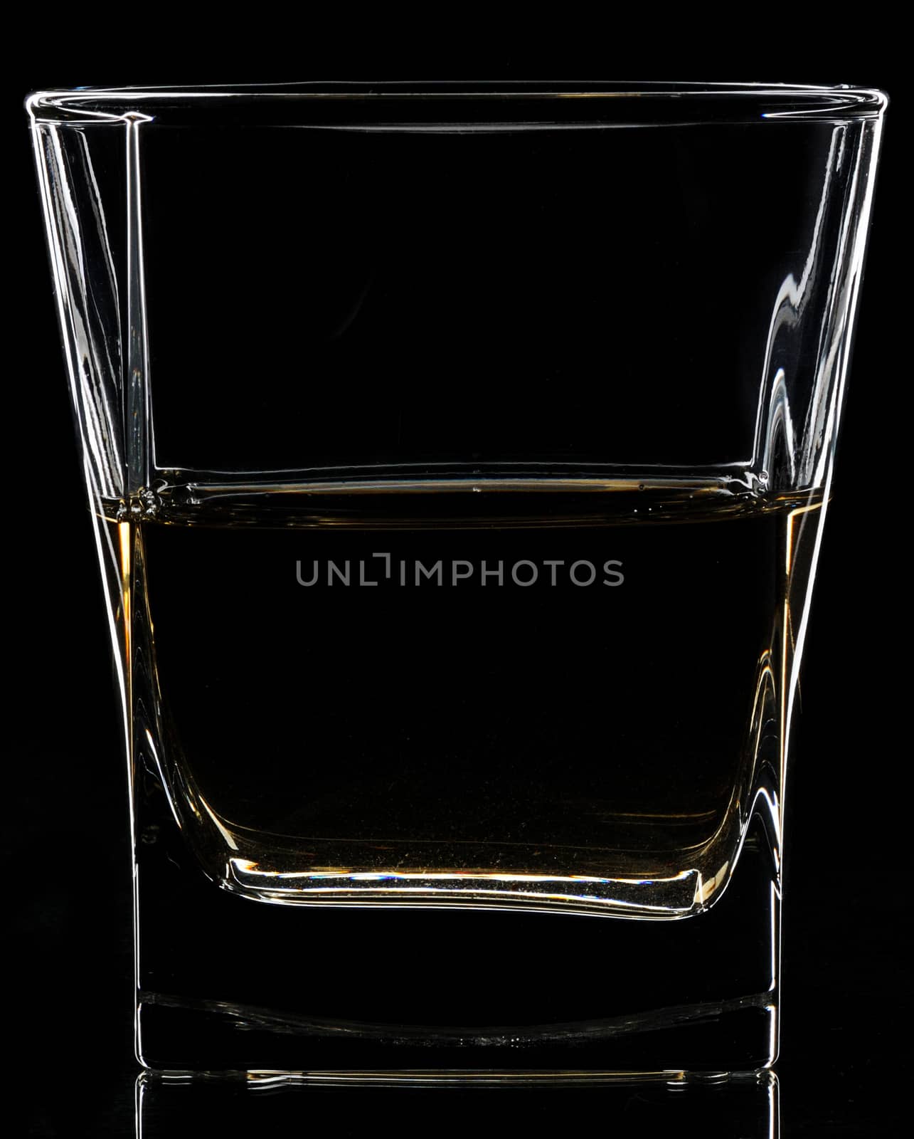 Glass with alcohol on black background