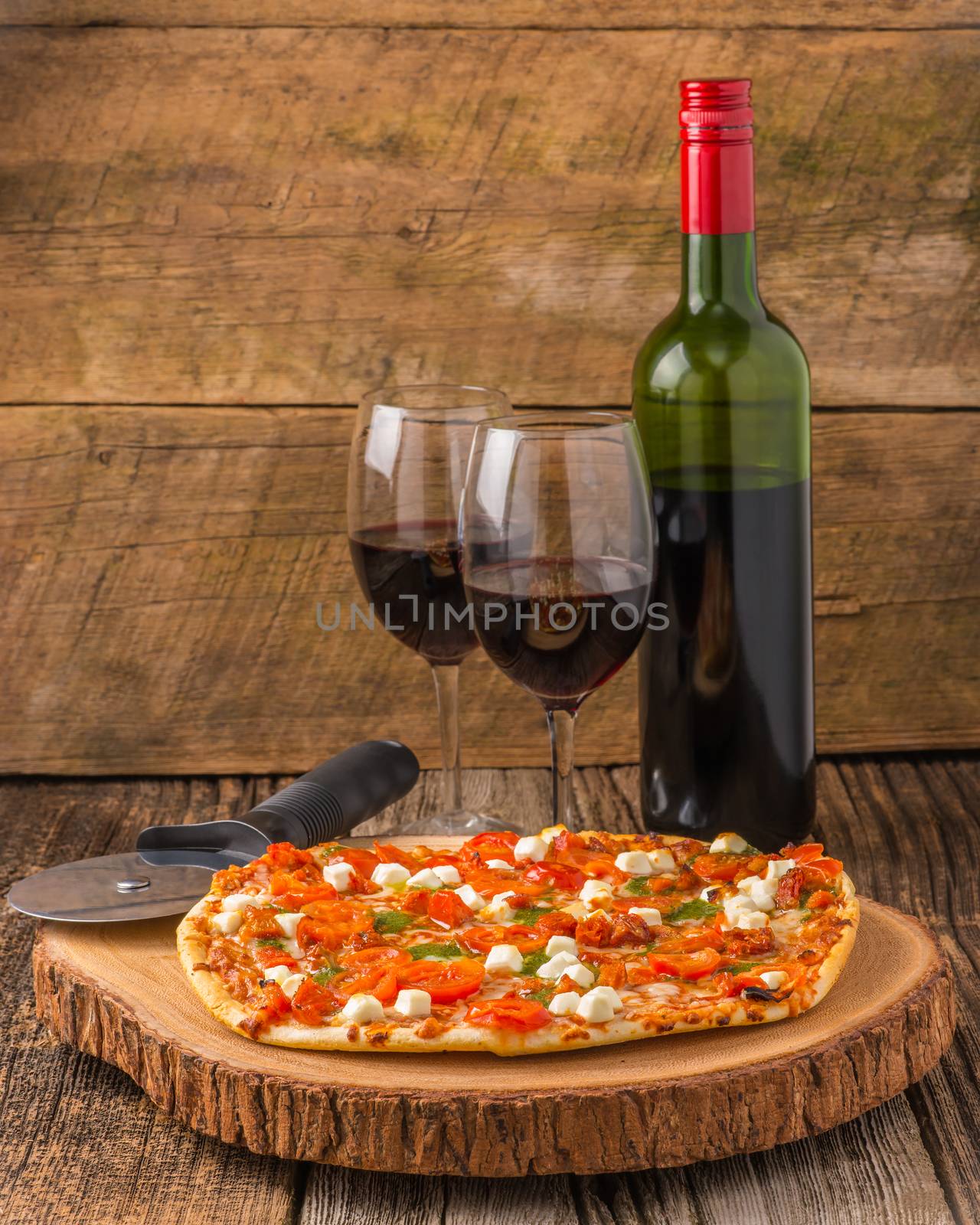 Homemade pizza served with a glass of red wine.