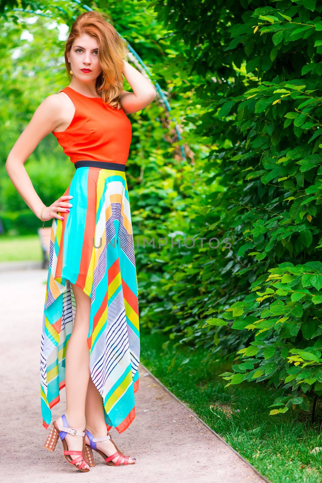 Fashionable slim woman in a bright dress outdoors