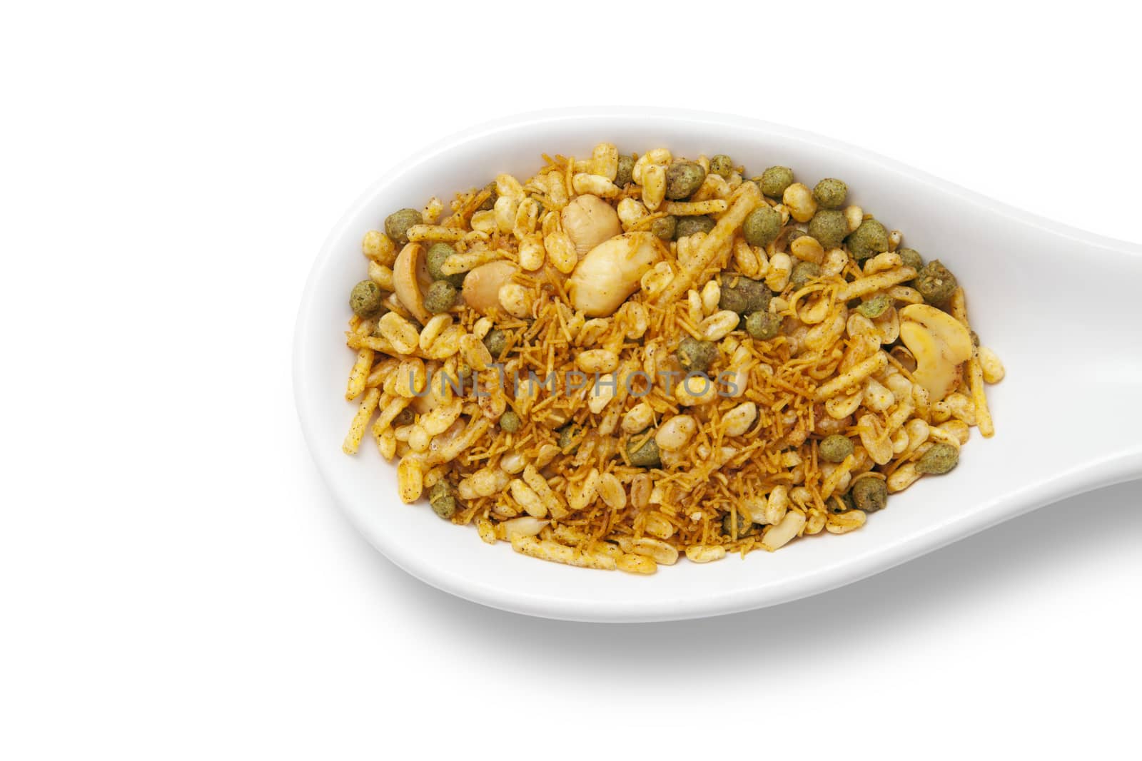 Dry roasted Indian snack mix in a big spoon, isolated
