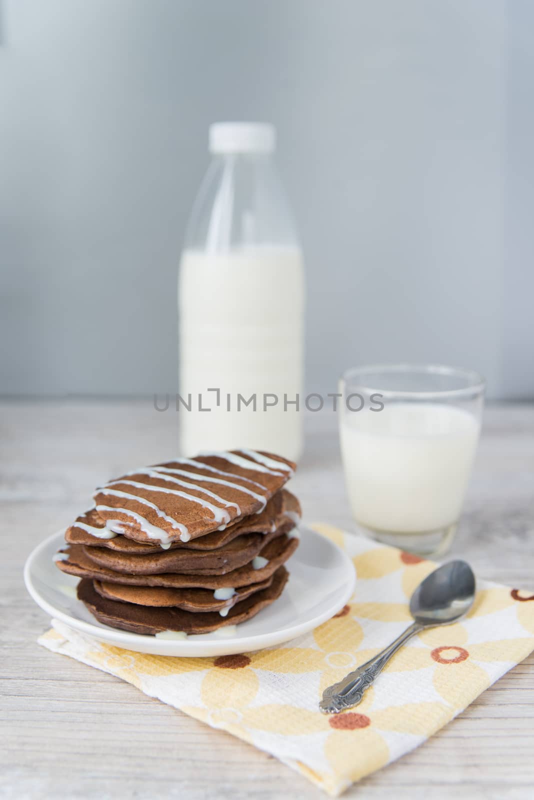 Chocolate pancakes with the glass and bottle of milk