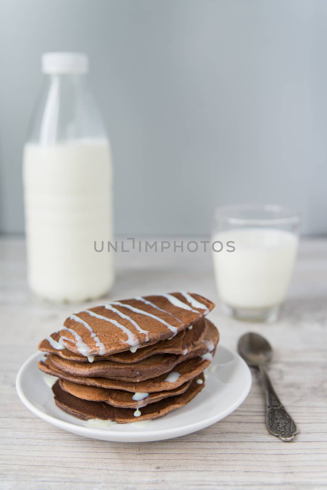 Chocolate pancakes with the glass and bottle of milk