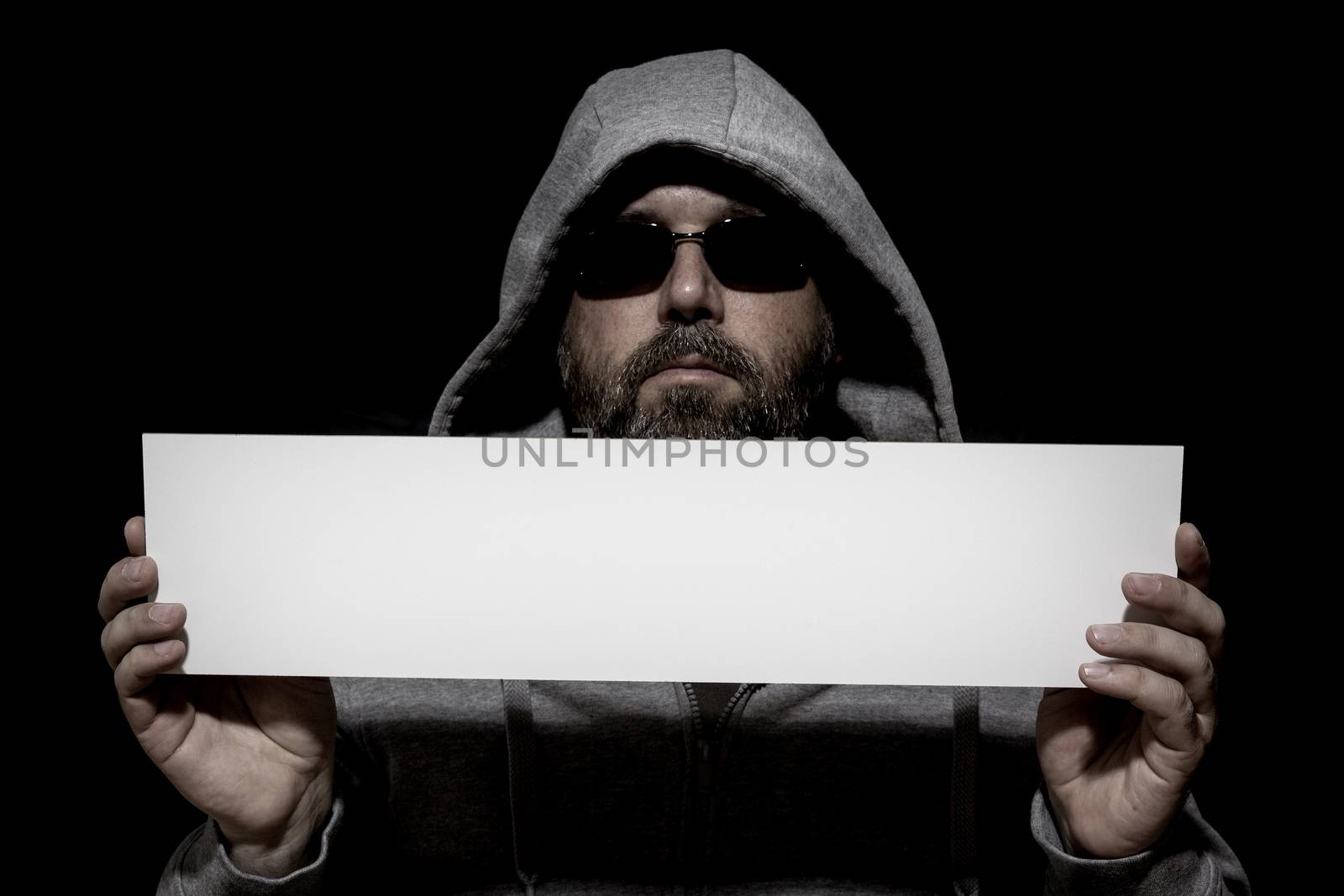 An image of an unrecognizable man in the dark with a white board