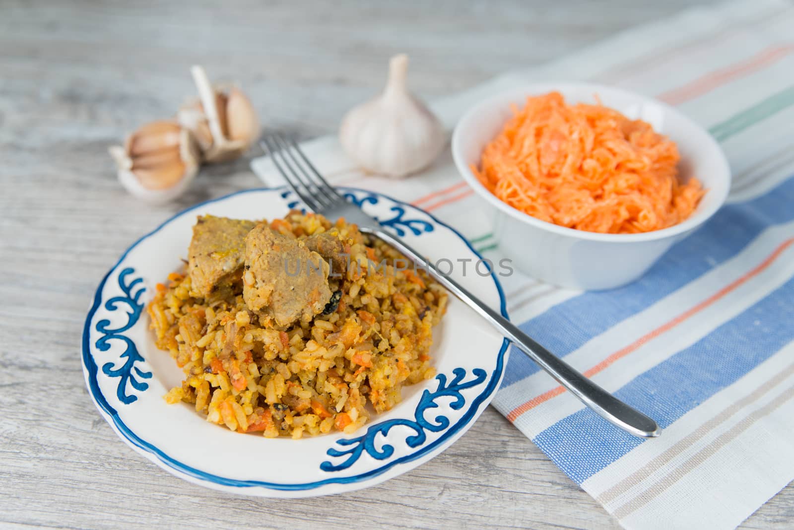 Plate of rice and meat national dish pilau with carrot salad