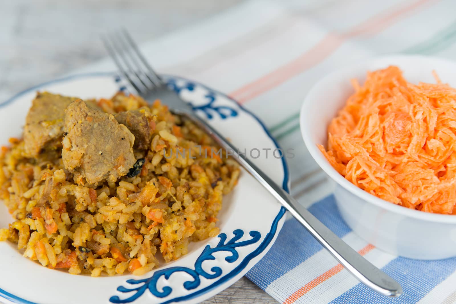 Plate of rice and meat dish pilau and carrot salad by Linaga