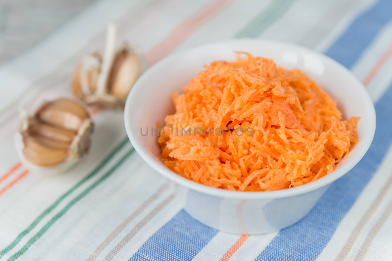 Carrot salad in the white plate with garlic
