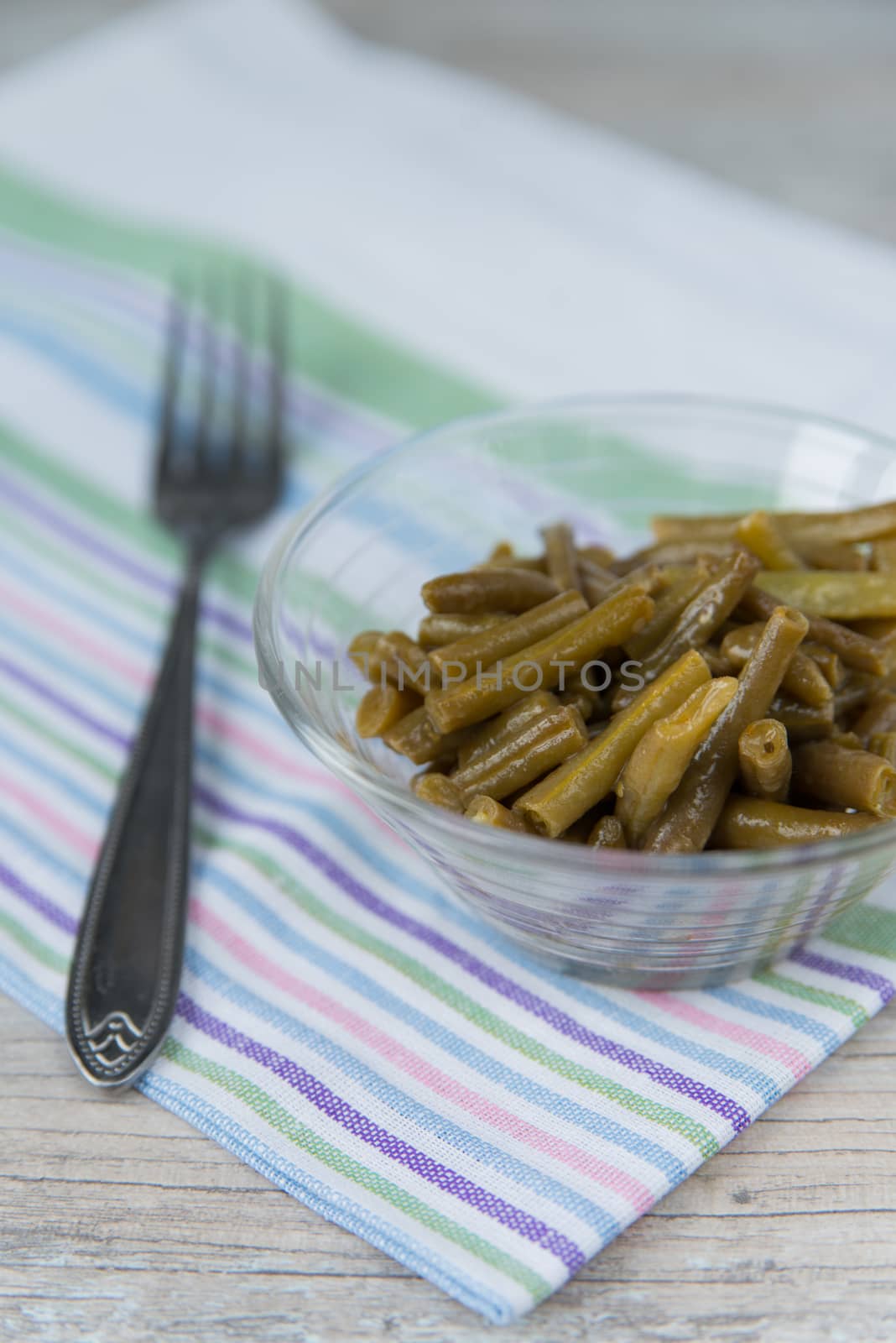 Plate of the prepared green beans and fork on the napkin