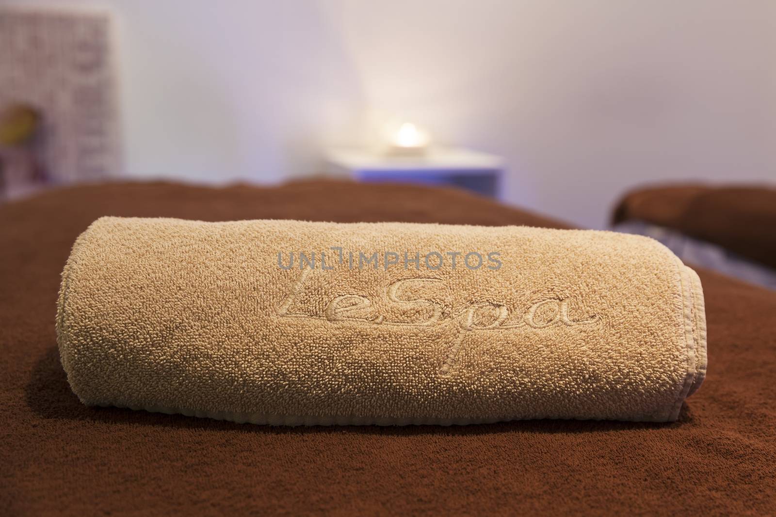 spa concept with candles, towel and part of massage table.