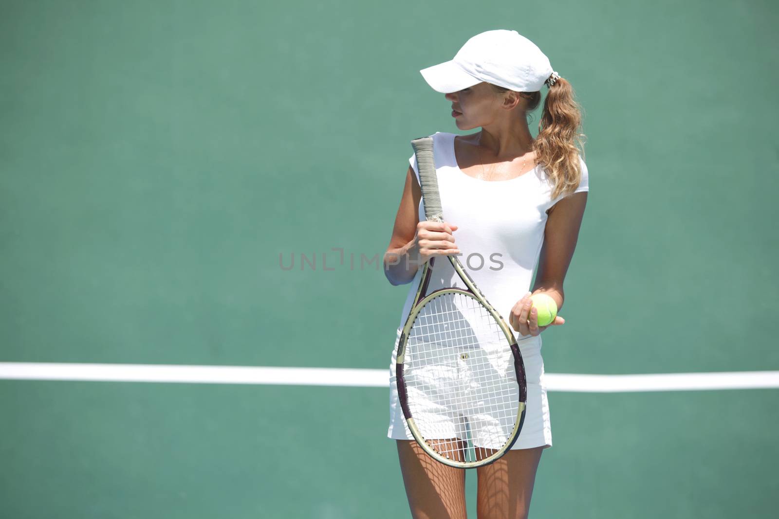 Young woman in white sportswear on tennis court