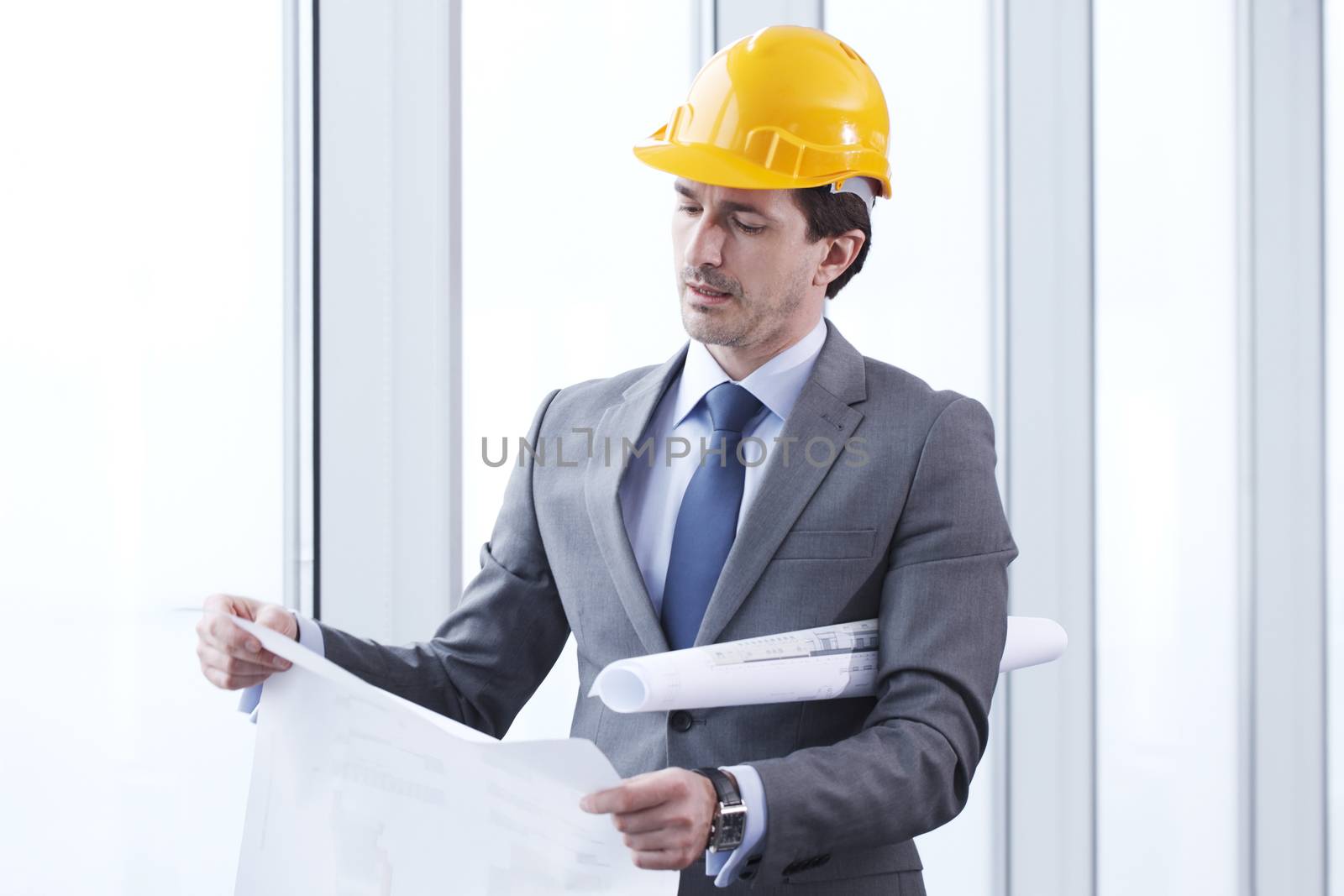 Architector in hardhat and business suit with construction plans