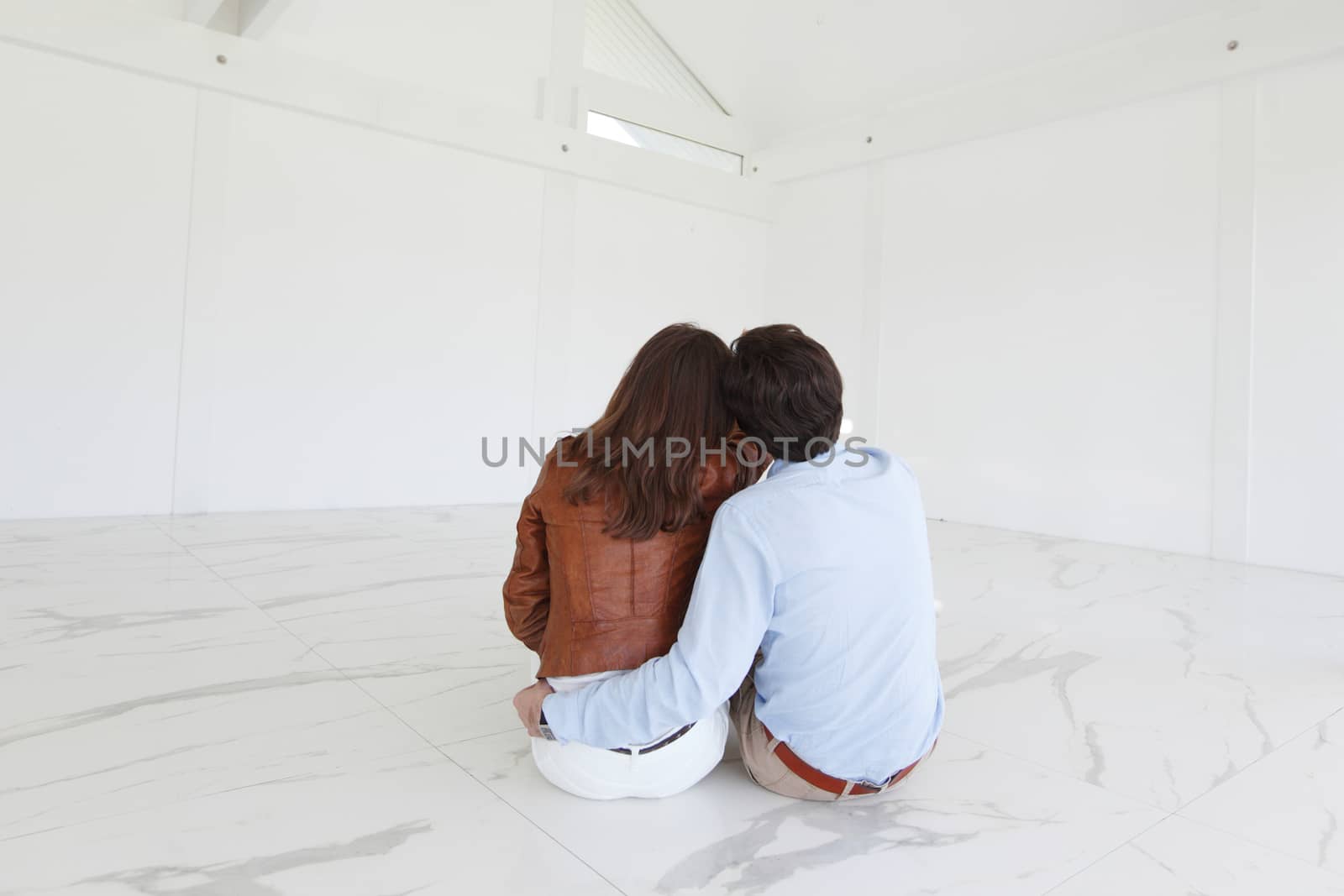 Couple sitting at their new empty apartment