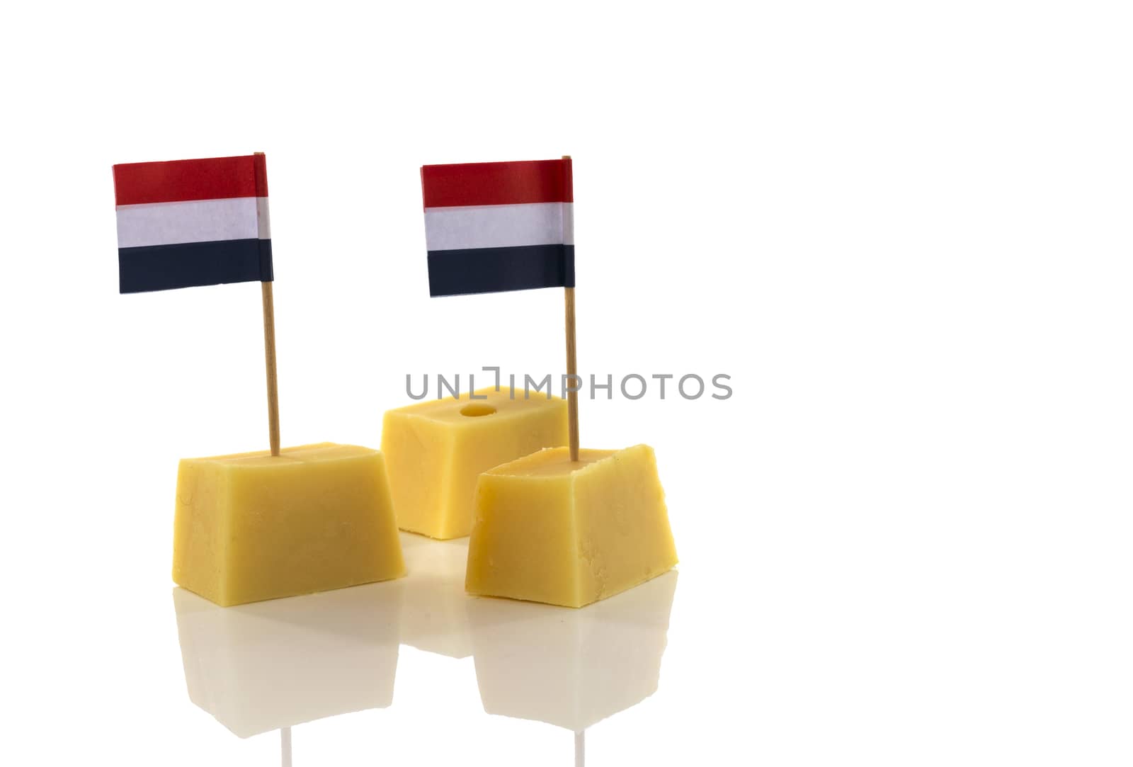 blocks of yellow Dutch cheese with Dutch flag in red white blue toothpicks on a white background