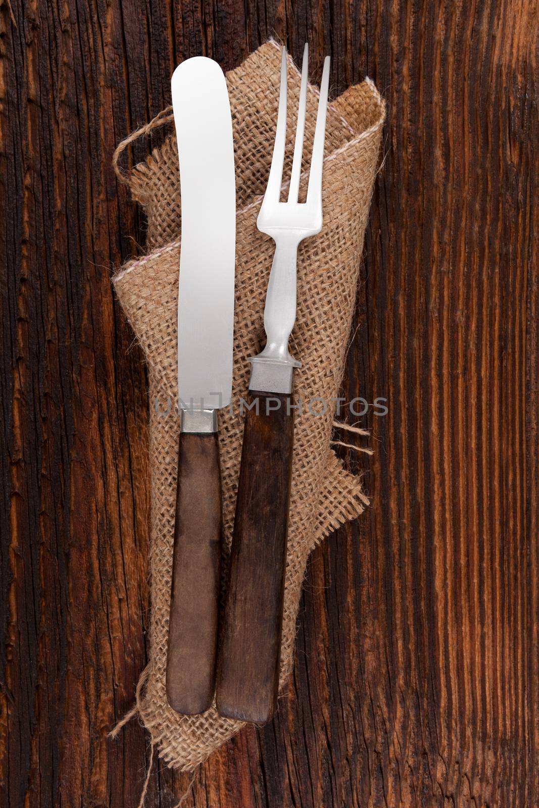 Old antique cutlery on wooden table, top view.