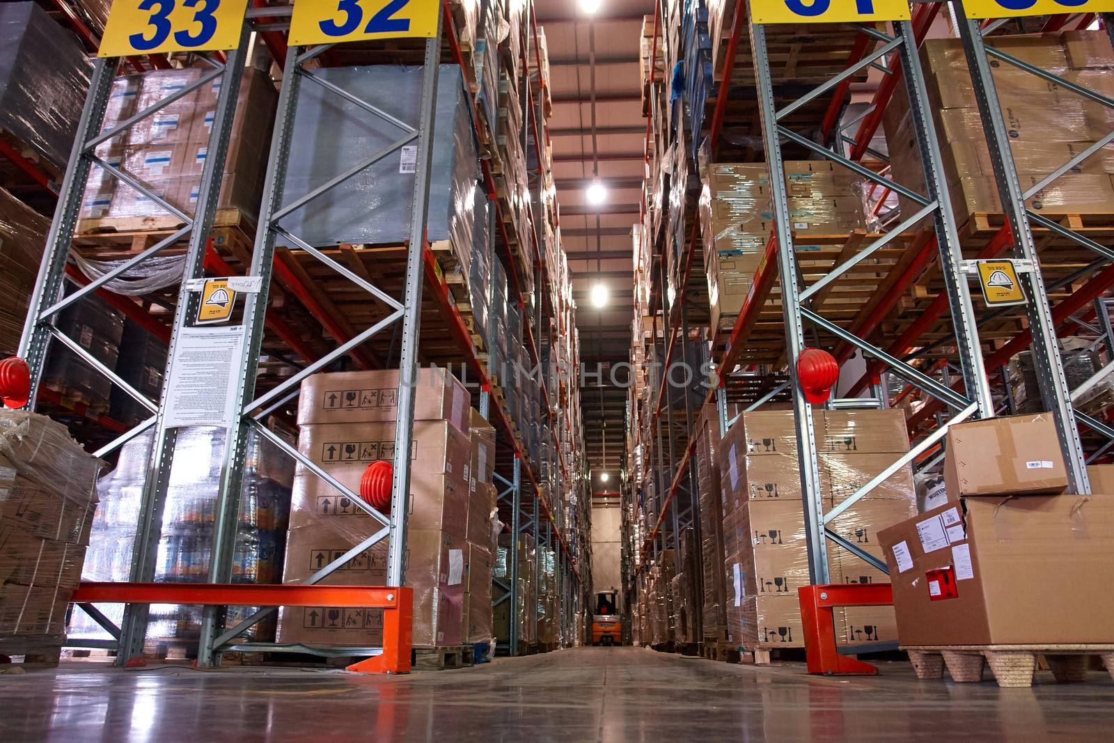 Large modern warehouse logistics center with rows of shelves with boxes                               