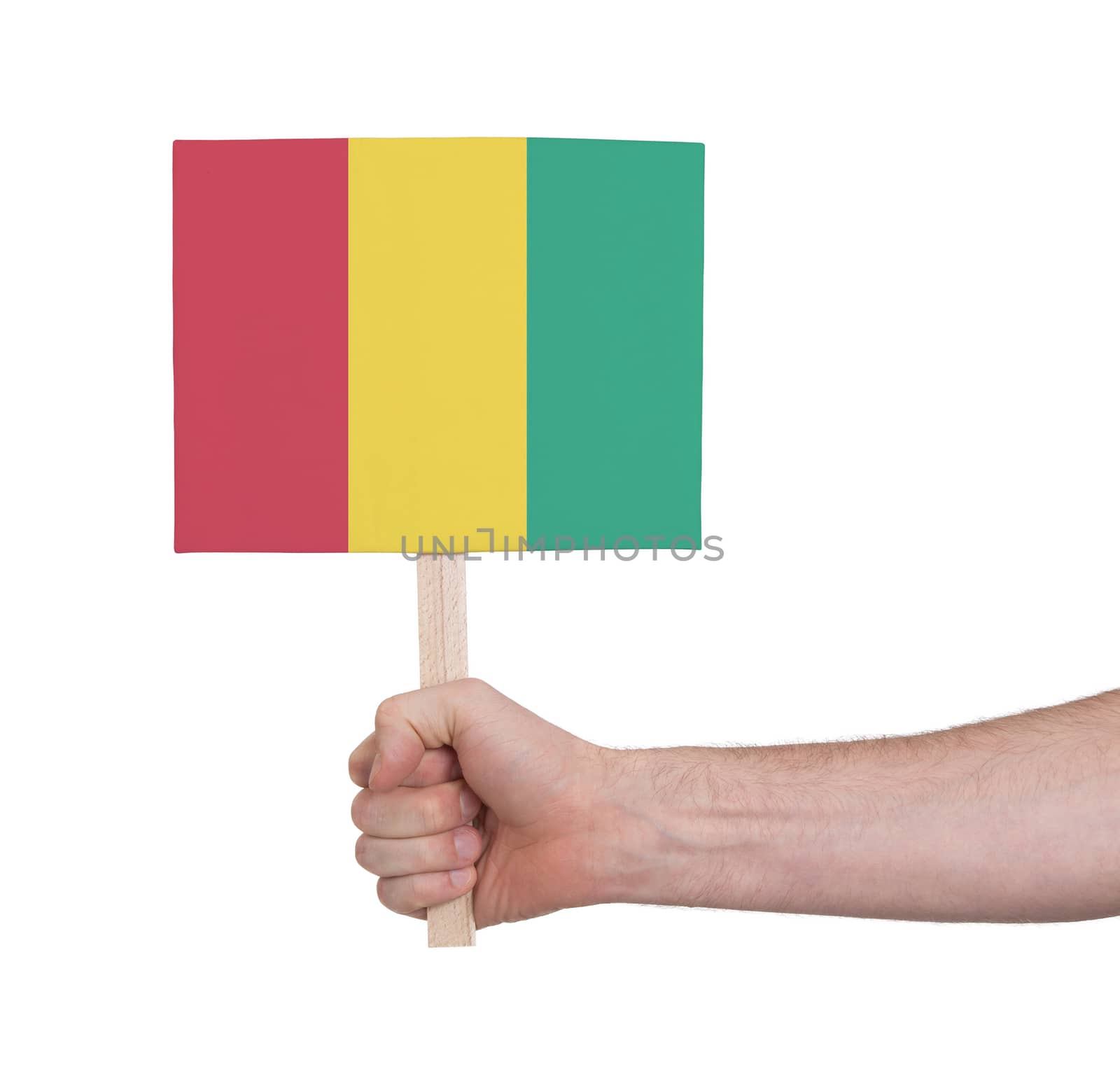 Hand holding small card, isolated on white - Flag of Guinea