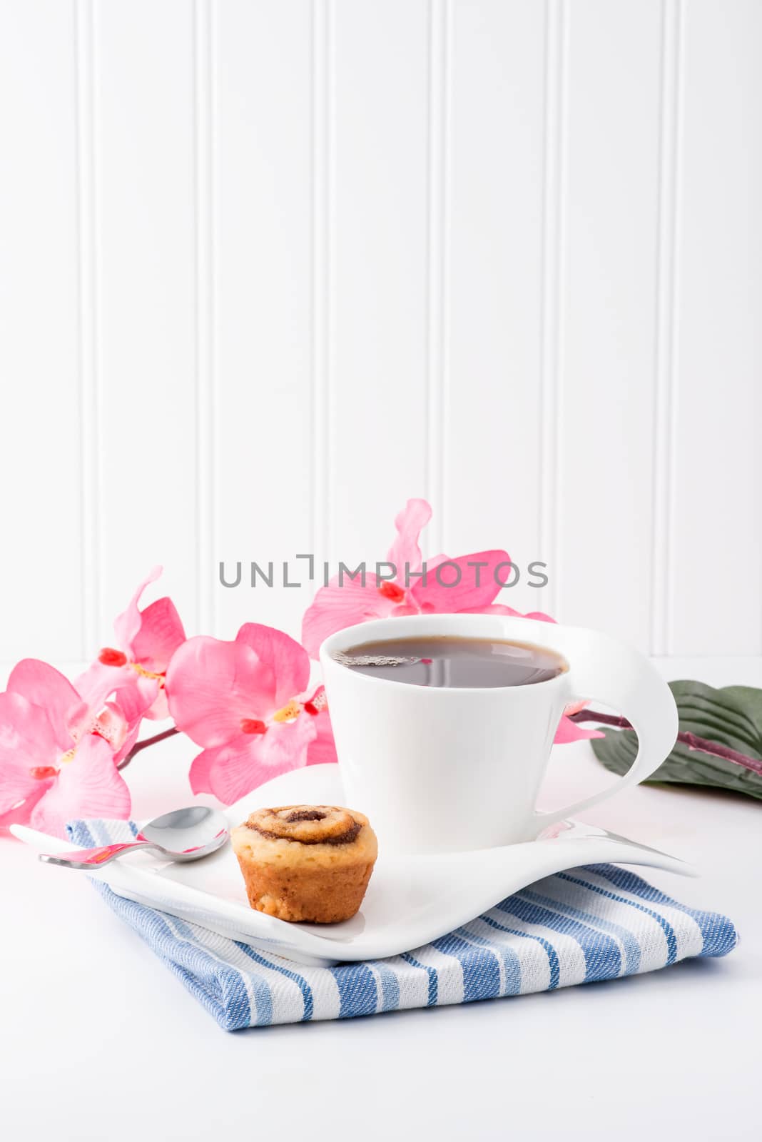 Mini cinnamon roll served with a cup of hot tea.