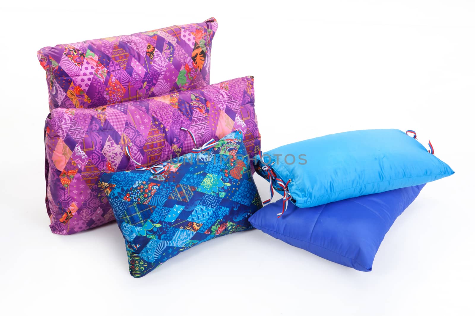 Five multicoloured down pillows on an isolated studio background