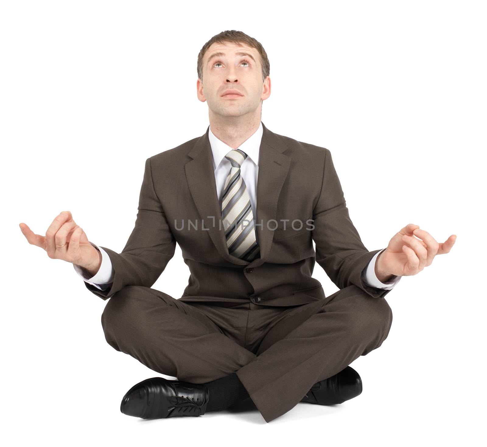 Businessman sitting in lotus posture and looking up isolated on white background