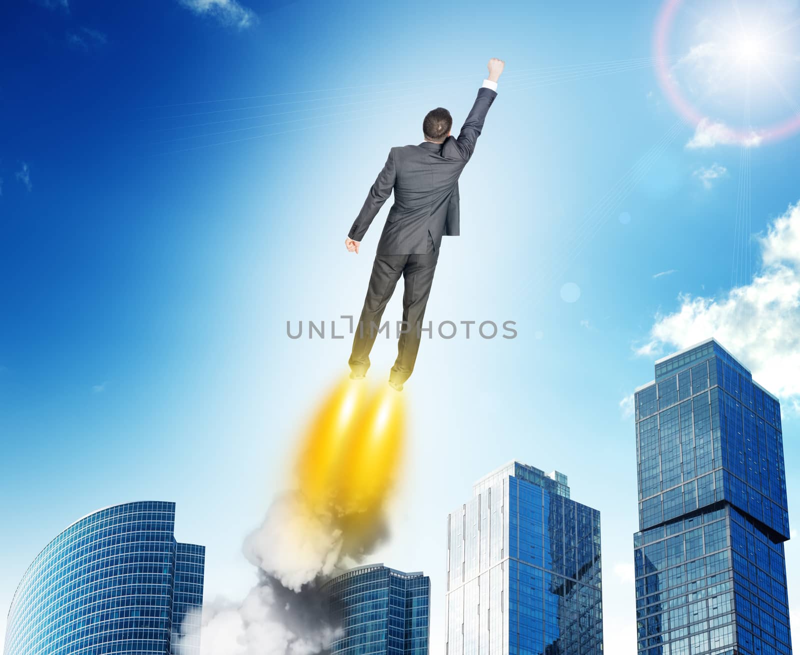 Businessman in suit flying above city, rear view