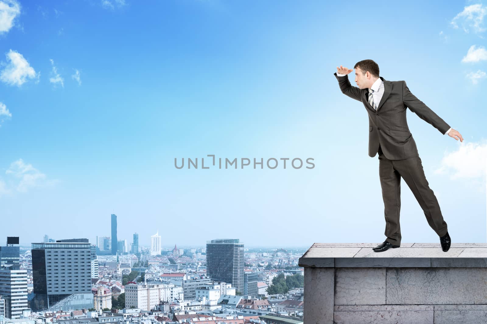 Businessman looking forward on building roof and cityscape background