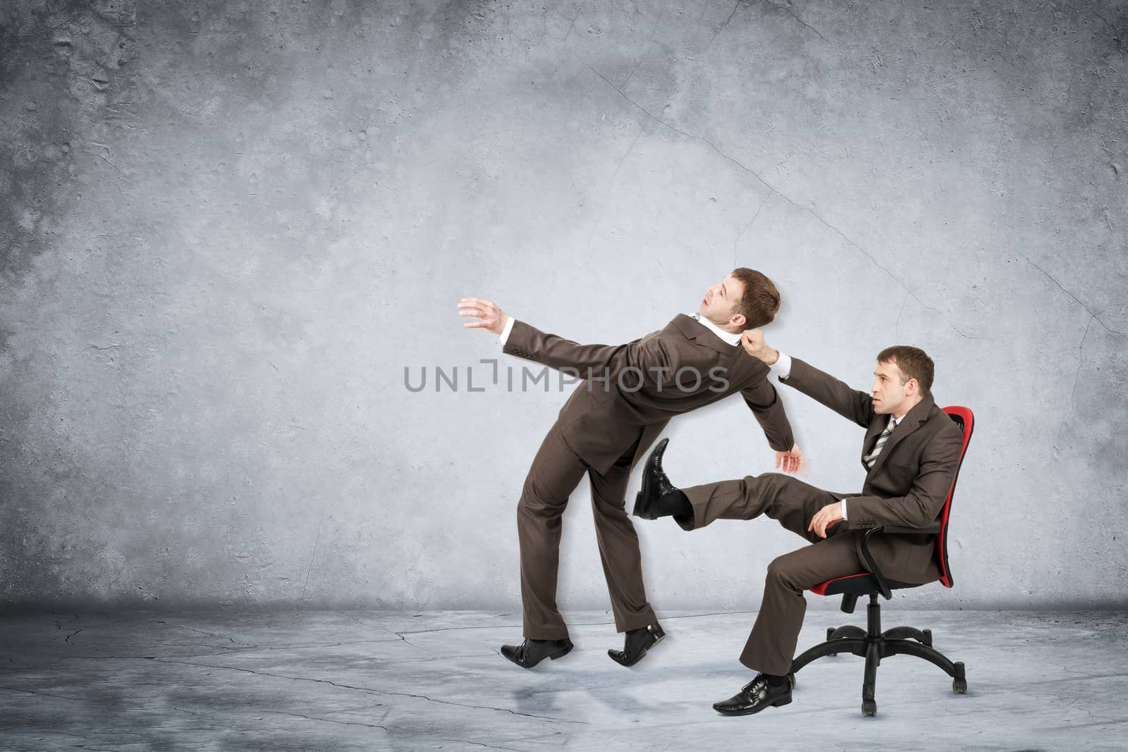 Businessman sitting on chair and kicking man on grey wall background