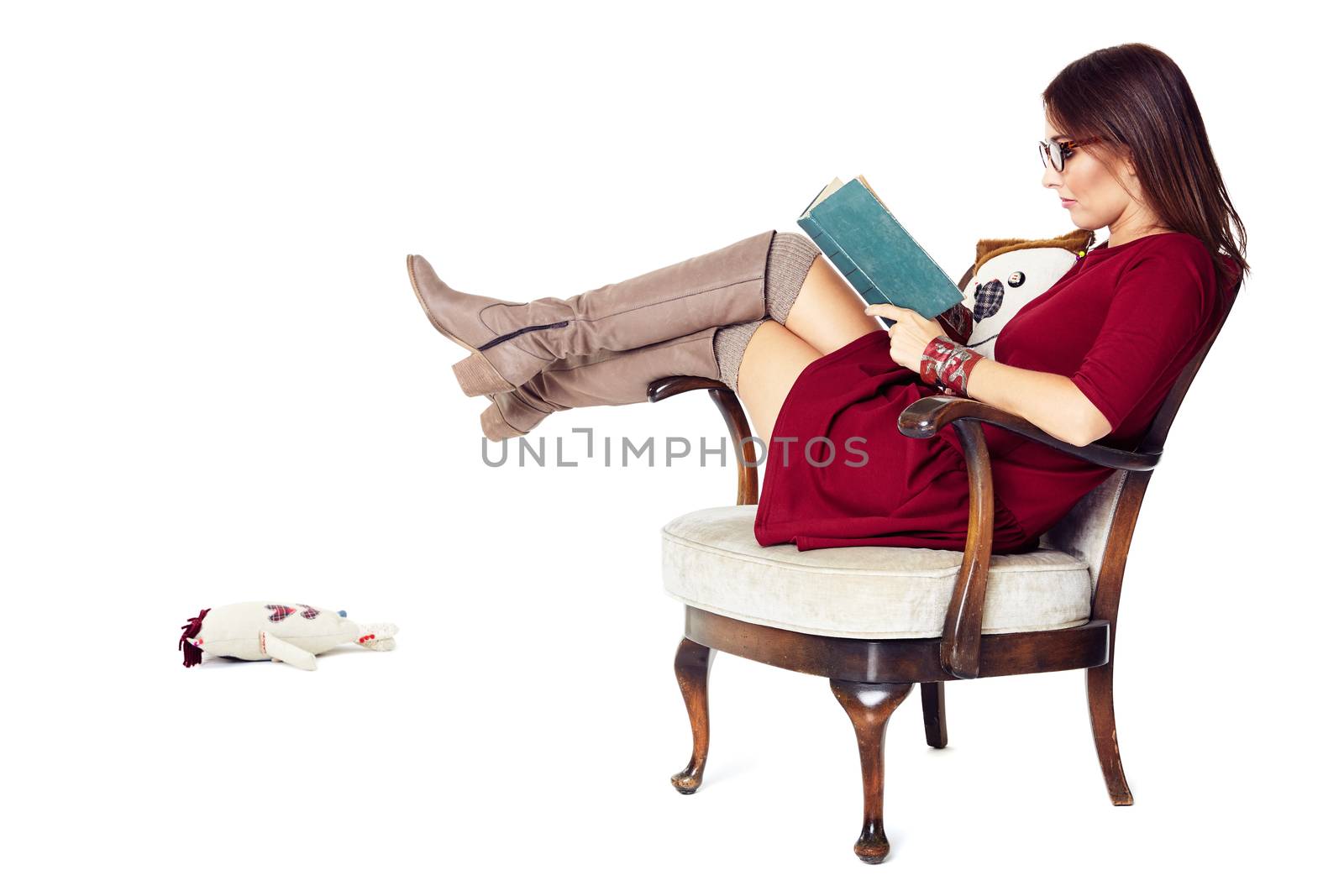 Attractive woman reading a book while sitting comfortably in an old chair.